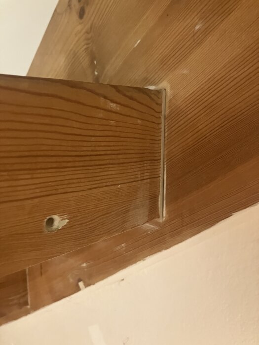 Trähörn av en trappa med synliga kanter och en borrad hålighet, del av en renovering.