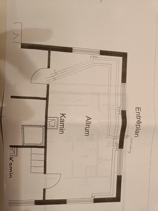 Planritning av ett hus med markerade rum som allrum och kamin på entréplan. Rördragningar och dörrplats syns.