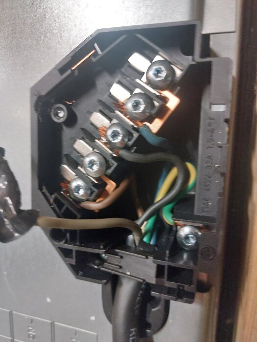 Hällens kopplingsdosa med kablar i olika färger anslutna till skruvterminaler, visar anslutningsschema för elektrisk installation.