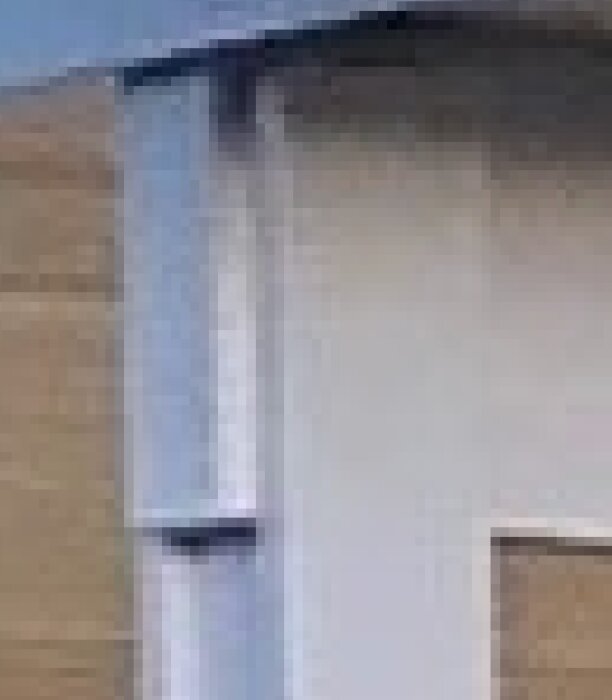 Detalj av en pelare med fästade brädor, liknande en 90x90 pelare av limträ.