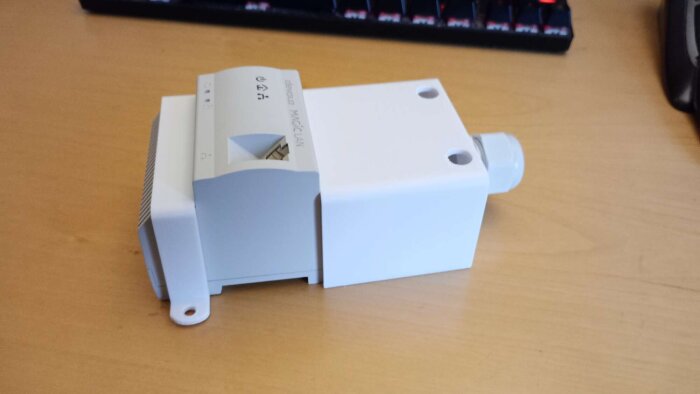 Devolo Magic LAN-adapter för strömnätverk visas liggande på ett träbord.
