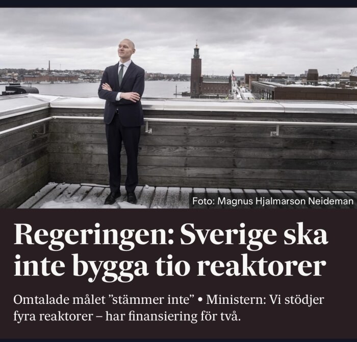 Man i kostym på takterrass, Stadshuset i Stockholm i bakgrunden, text om regeringens mål för kärnreaktorer.