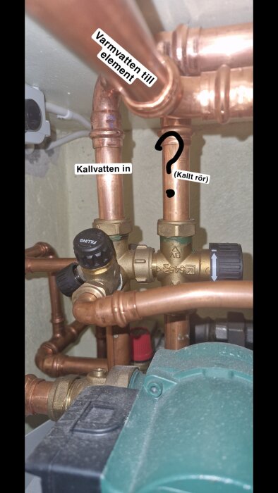 Kopparrör och ventiler i källaren, märkta "Kallvatten in", "Varmvatten till element" och "?" för ett oidentifierat kallt rör.