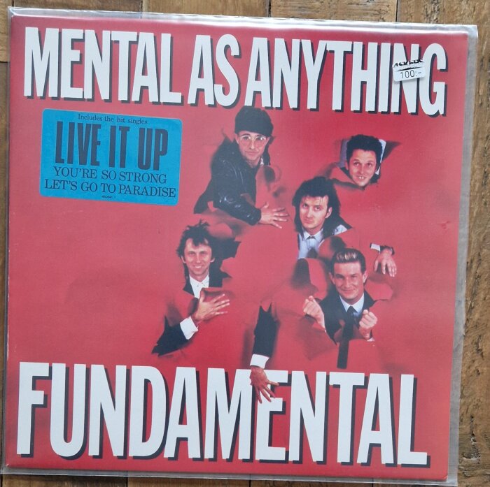 Skivomslag för albumet "Fundamental" av bandet Mental As Anything, med medlemmar på en röd bakgrund och blå etikett med låttitlar.