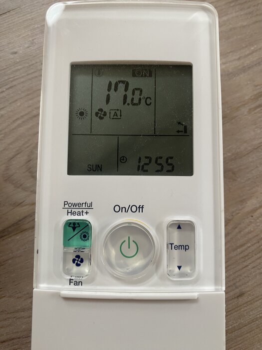 Handkontroll för fläkt med display som visar 17 grader och andra symboler för inställningar. Knappar: Powerful Heat, On/Off, Temp och Fan.