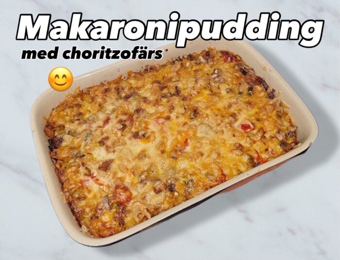 Makaronipudding med chorizofärs i en ugnsform, toppad med smält ost.