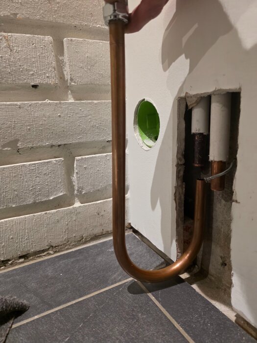 En kopparrörsböj monterad nära en vägg, visar ett C/C-avstånd som kan vara för långt för optimal radiatoranslutning.