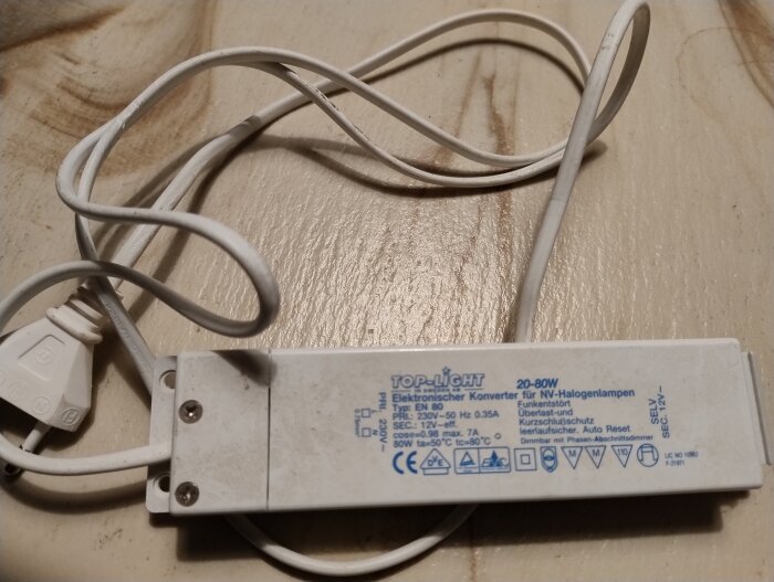 Vit elektronisk transformator för halogenlampor, märkt "TOP-LIGHT", med ansluten vit elsladd.