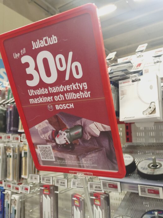 Skylt med rea på 30% för utvalda handverktyg och tillbehör hos Jula. Bosch-produkter visas i bakgrunden.