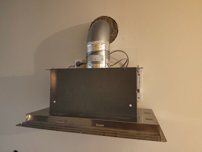Ventilationsinstallation med spirorör, brandspjäll och isolering i en vägg, inklusive ytterhuva med kallrasskydd.