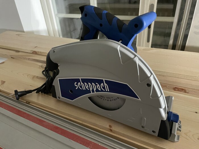 Cirkelsåg av märket Scheppach placerad på ett trägolv med elkabel i förgrunden.