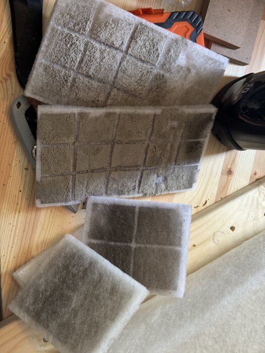Smutsiga FTX-filter, ett grovfilter och mindre uteluftfilter, efter sex månaders vinteranvändning, liggande på ett bord.