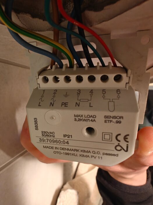 Termostatanslutning med trådar i olika färger, markerad med "MAX LOAD 3,2KW 14A" och "MADE IN DENMARK KIMA".
