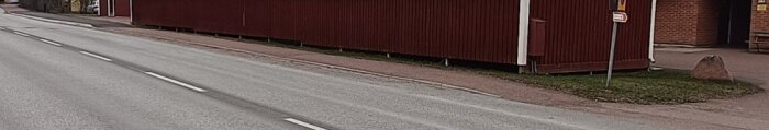 En upphöjd infart syns längst upp till vänster, jämfört med en lägre infart till höger. Röda byggnader och en väg syns i bakgrunden.