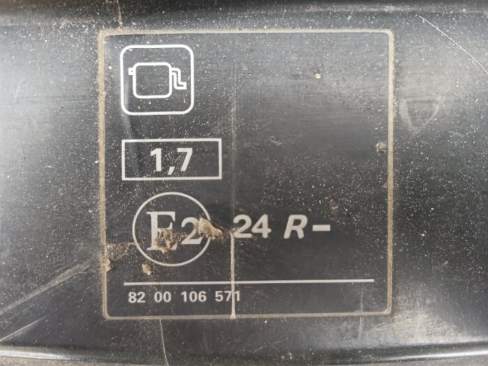 Text och symboler på en bilkomponent, inklusive oljefilterikon och siffrorna "1,7", "F2", "24 R-", samt serienummer "82 00 106 571".
