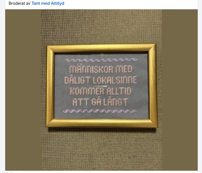 Broderad tavla med texten "Människor med dåligt lokalsinne kommer alltid att gå långt" i en gyllene ram på beige bakgrund.