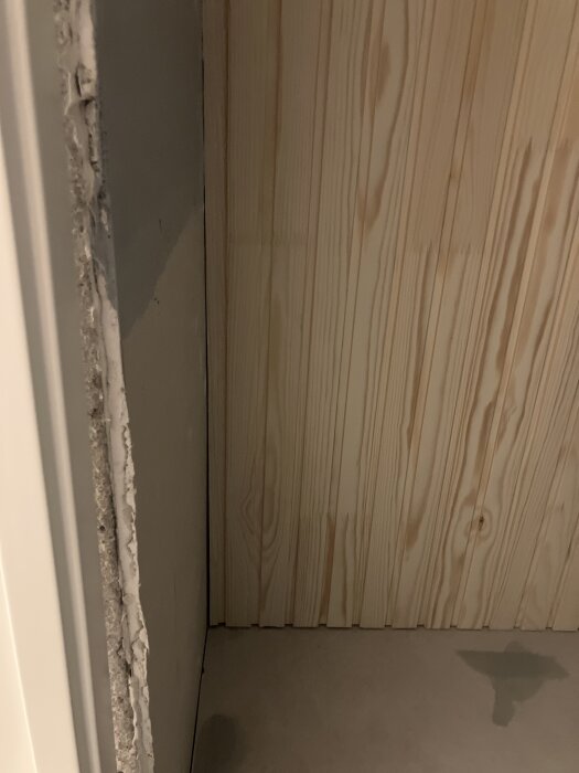 Furupanel i ett badrumstak med högst 2 mm mellanrum till väggen, under badrumsrenovering.