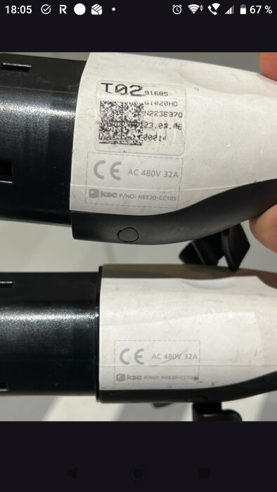 Närbild av en vit laddkabel med märkningen "AC 480V 32A". Text om trefas och enfas diskussion på etiketten.