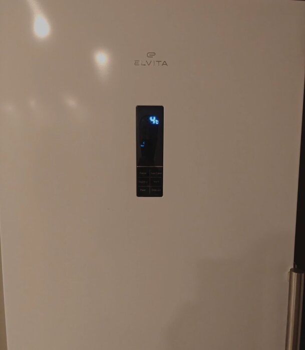 Elvita frys med digital display som visar 4°C, ej kylande trots strömförsörjning, fotograferad för problemlösning.