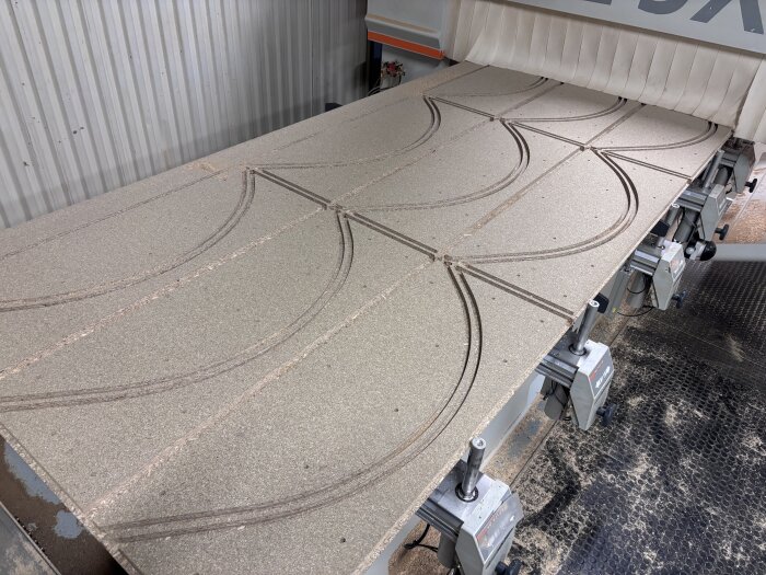 CNC-maskin skär svängda luckor i en skiva för ett renoveringsprojekt, del av ett barbygge.