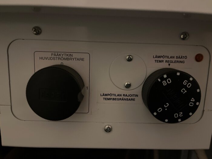 Kontrollpanel för ett vattenvärmesystem med vred för temperaturinställning och på/av-knapp.