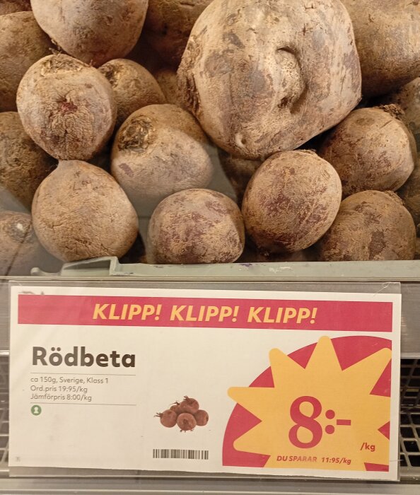 Rödbetor i en korg med en skylt som visar priset 8 kr/kg, med information om ursprung och jämförelsepris.