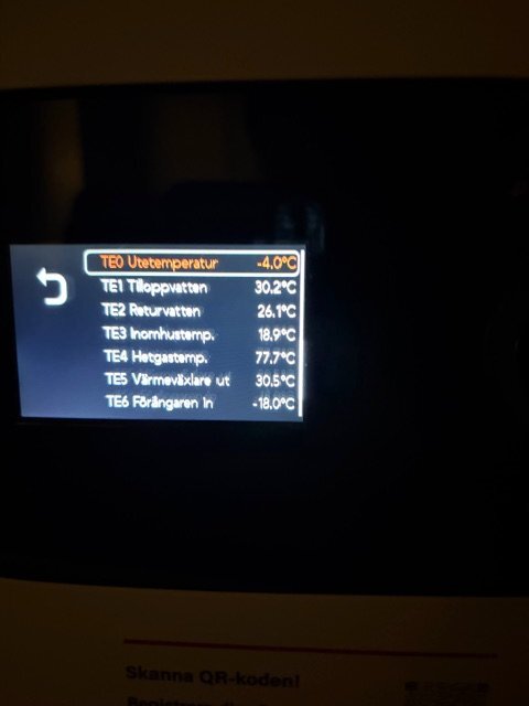 Display på värmepump som visar olika temperaturer: tilloppvatten 30,2°C, returvatten 26,1°C, inomhus 18,9°C, ute -4°C, hetgas 77,7°C.