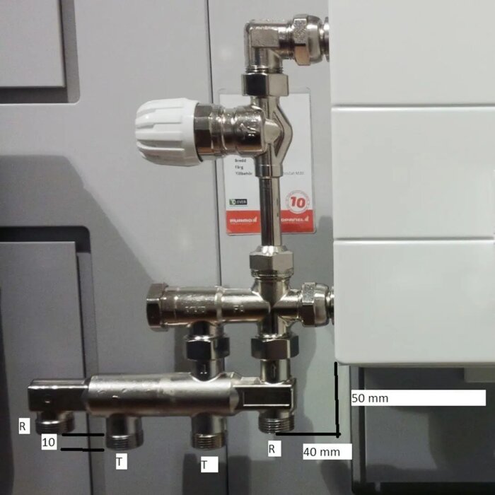 Ventilsystem med fördelare och termostatventil för rörkopplingar i ett VVS-projekt, markerade mått och röranslutningar.