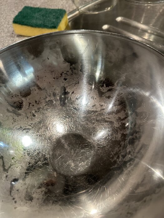Metallbunken har fläckar och repor; en disksvamp ses i bakgrunden.