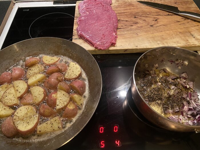 Stekpanna med stekt potatis, gryta med lök och kryddor, samt rå flankstek på skärbräda.