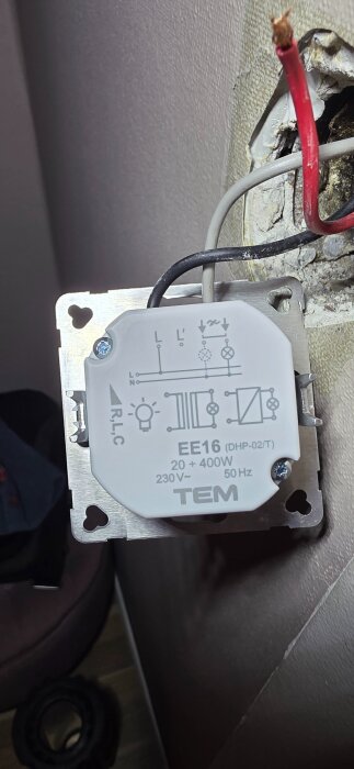 Elinstallationsdosa med dimmer, märkt "TEM EE16", visar inkopplad svart kabel och lösa röda och grå kablar.