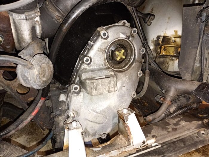 Motorområde av en Saab med synlig primärkedjehus före borttagning. Området är rengjort och förberett för byte av delar och reparation.