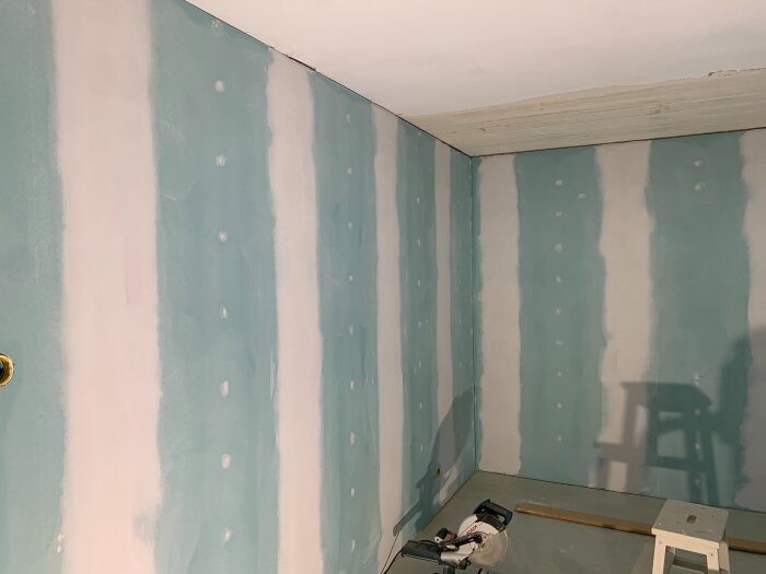 Renovering av sovrum med gipsade och spacklade väggar, en cirkelsåg och en stege står på golvet i förgrunden.