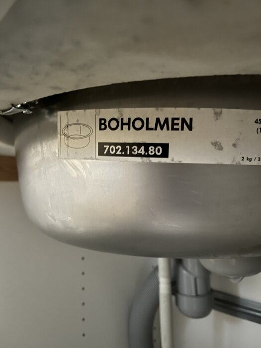 Etikett på diskbänk med texten "BOHOLMEN 702.134.80", visar delnummer för IKEA köksprodukt.