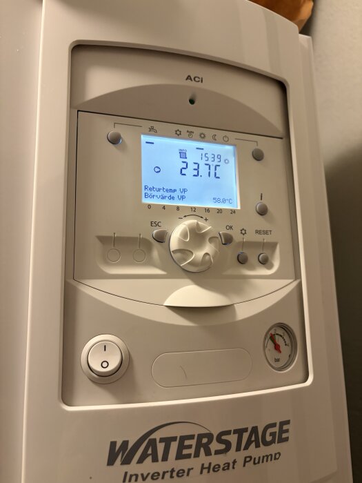 Bild av kontrollpanel för inverter-värmepump med digital display som visar 23,7°C returetemperatur och 58,0°C börvärde, märket är Waterstage.