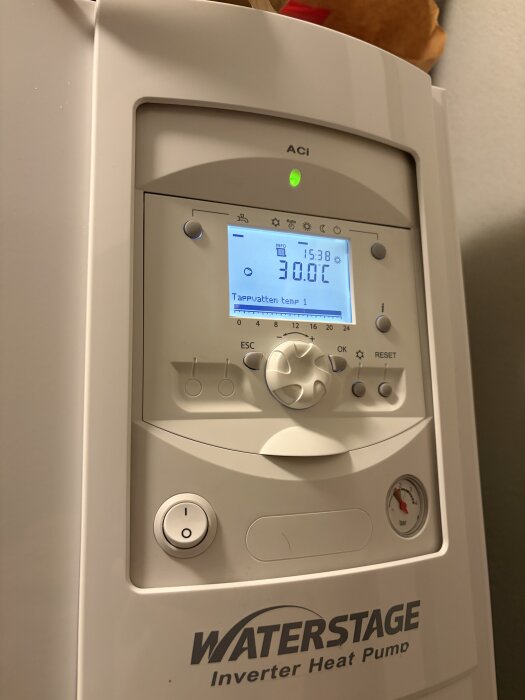 En vit Waterstage invertervärmepump med en digital display som visar temperatur och inställningar.