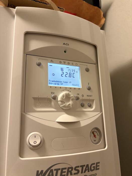Värmepumpens kontrollpanel med temperaturdisplay som visar 22,8°C och tryckmätare.
