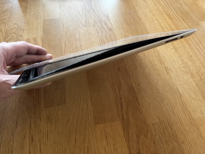 Svullet batteri i äldre enhet som delvis öppnat baksidan.