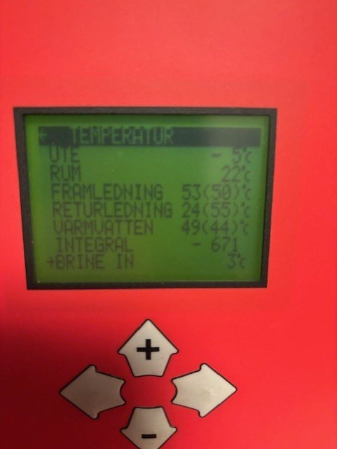 Display av bergvärmepump, visar olika temperaturer: framledning 53°C, returledning 24°C, samt ute och rumstemperatur. Inkluderar styrknappar.