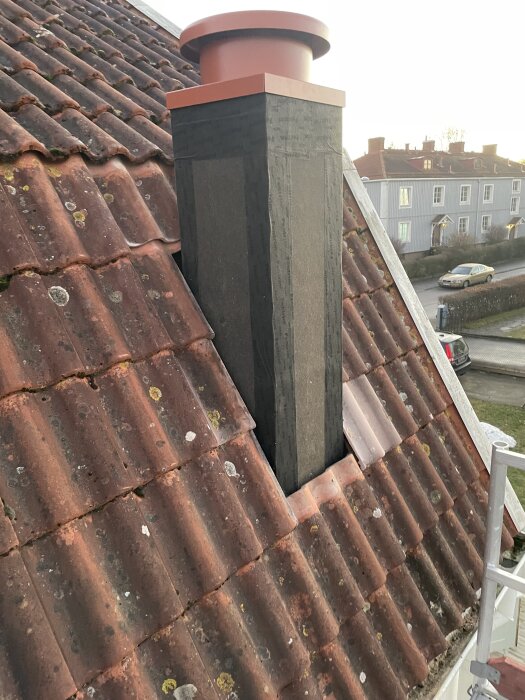 Ventilationskanal med ljuddämpare och extern fläktmotor placerad på ett tegeltak, del av ett köksrenoveringsprojekt.