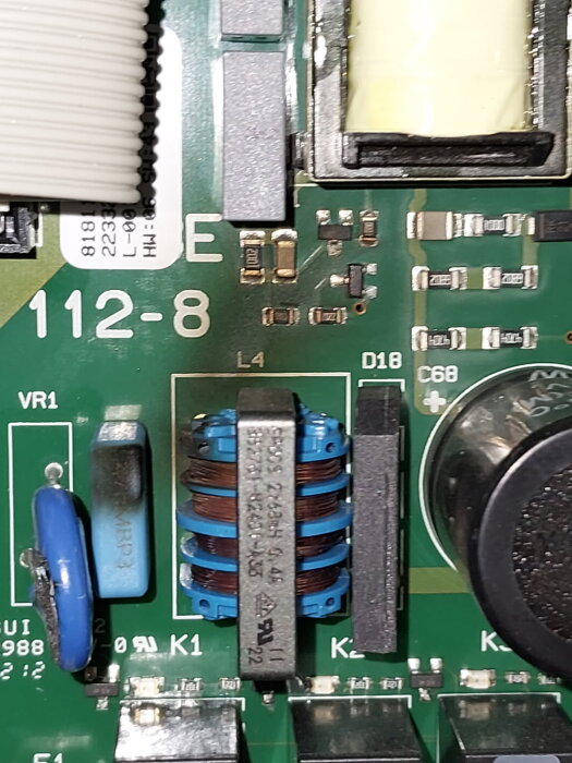 Elektroniskt kretskort med komponenter som kondensatorer, motstånd och inductor, märkta med olika nummer och bokstäver.