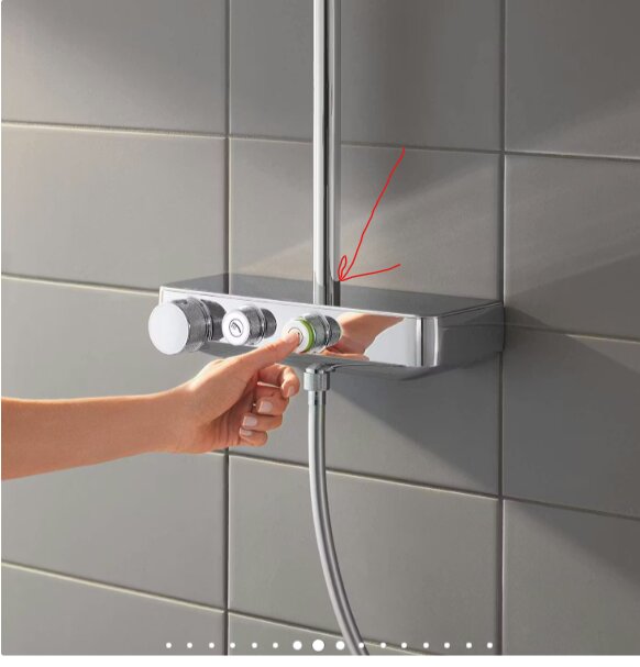 En person justerar inställningar på en Grohe Euphoria 260 Mono duschanordning monterad på kakelvägg. En röd pil pekar mot duschstången.