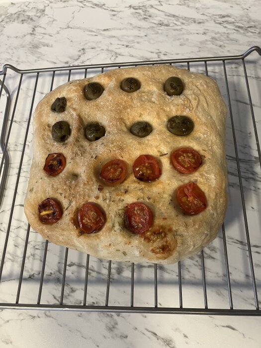 Focaccia med oliver och tomater på ett galler, bakad i airfryer och jäst i kylskåp över natten.