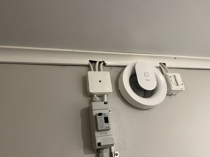 Elinstallation med RKK-kabel på en vägg, synliga kablar, strömbrytare och PAX-fläkt.