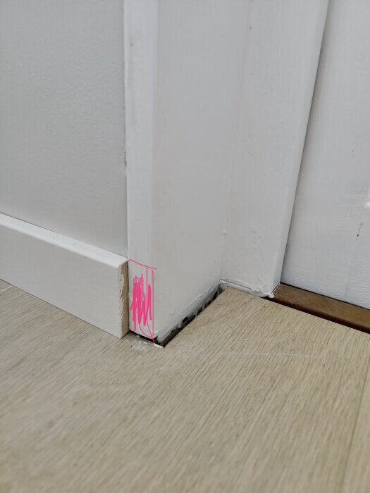 Närbild av dörrpost mot golv med rosa markering där justering och avrundning med list föreslås för ett snyggare avslut.