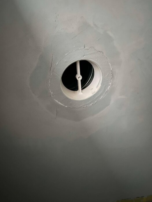 Nytt rör installerat i taket, fastsatt i muffen, med gipsdon på plats.