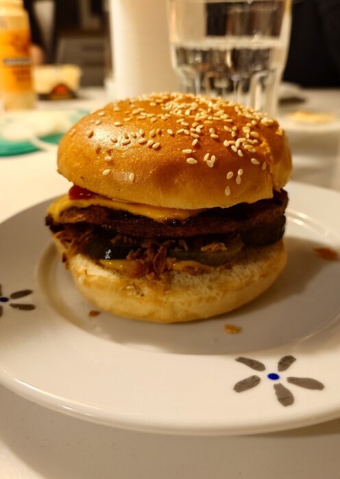 En hamburgare med sesambröd, ost och pickles på en tallrik, burgaronsdag-tema.
