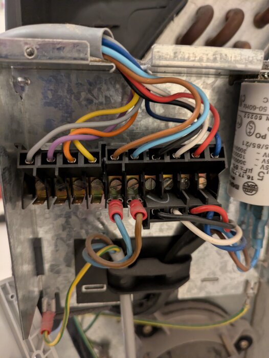 Inre komponenter i en Carrier 42NM fläktkonvektor med synliga sladdar och anslutningar, inklusive en del av ett kopplingsschema.
