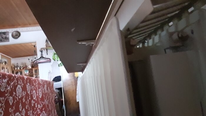 Element i ett rum, nära ett bord eller fönsterbräda, med inredning och dekoration i bakgrunden.