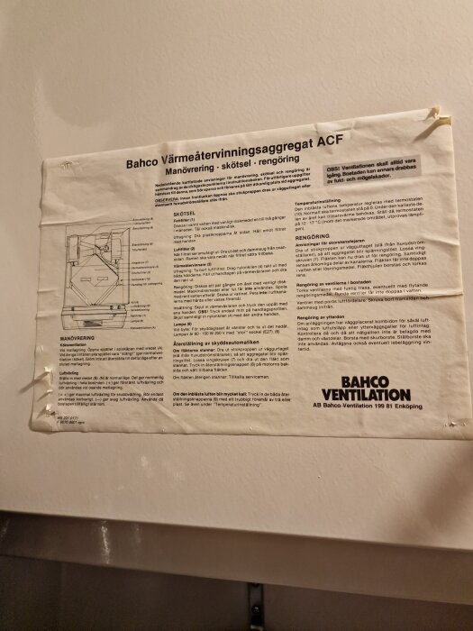 Instruktionspapper för Bahco värmeåtervinningsaggregat ACF på vit vägg, innehållande skötsel- och rengöringsanvisningar.